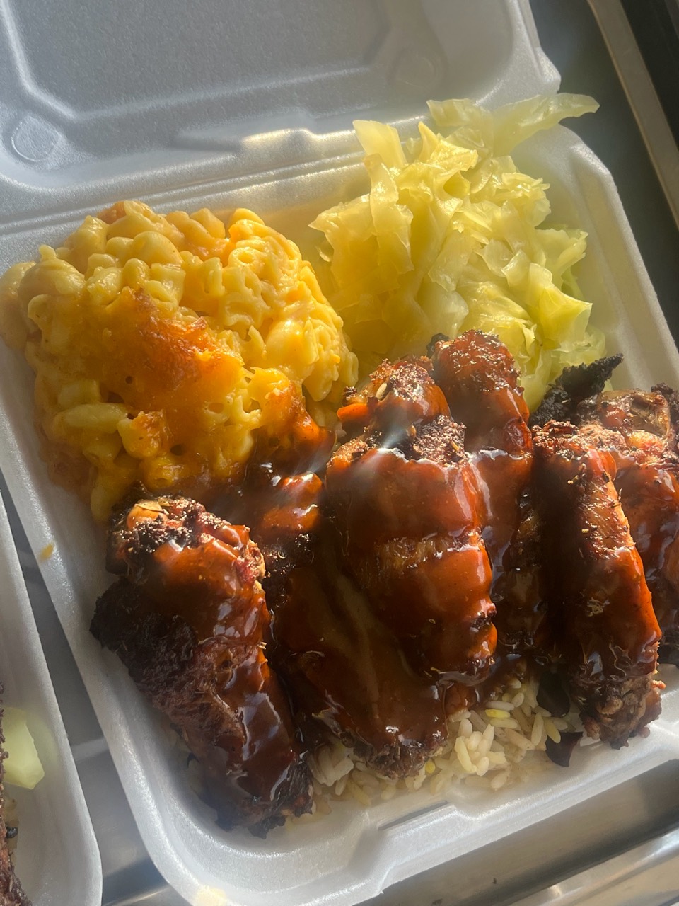 Island Boy Kreationz wing plate with macaroni and cheese, cabbage, rice, and sauce